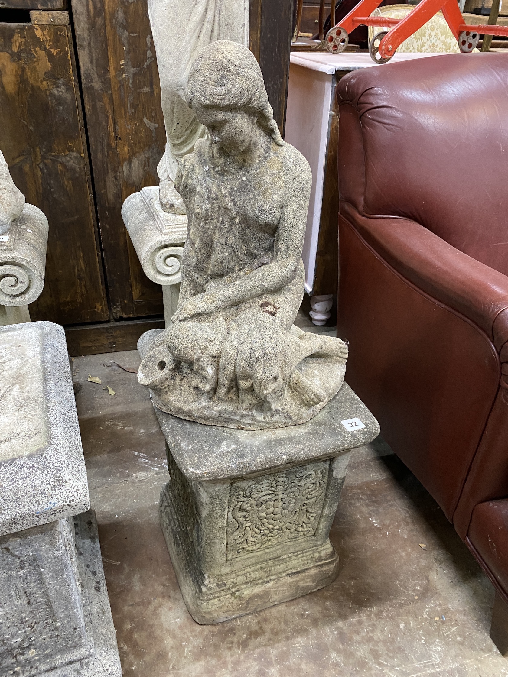 A reconstituted stone garden ornament of kneeling woman, on square plinth, height 86cm